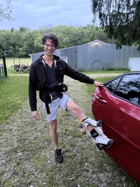 Gabriel wearing the first white-printed Kicker on his leg beside a car, battery and controller on his belt